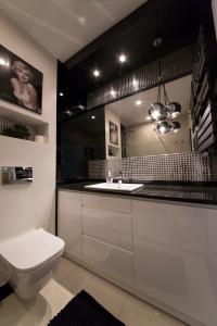 a bathroom with a white sink and a toilet at Wyspa Uznam - Rondo Róży Wiatrów in Świnoujście