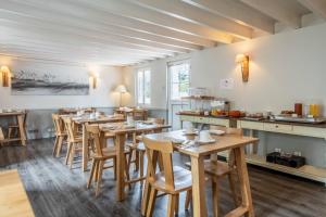 uma sala de jantar com mesas e cadeiras de madeira em Hotel Le Clos Fleuri em Le Palais