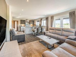 a living room with couches and a kitchen at Haven Cottage in Blackburn