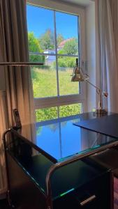 einen Glasschreibtisch vor einem großen Fenster in der Unterkunft Exklusive Ferienwohnungen und Business Apartments Marburg in Marburg an der Lahn