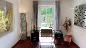 ein Wohnzimmer mit einem Stuhl und einem Fenster in der Unterkunft Exklusive Ferienwohnungen und Business Apartments Marburg in Marburg an der Lahn