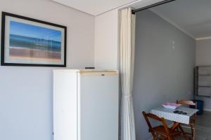 a room with a table and a picture on the wall at Residencial Solar do Pescador in São Sebastião