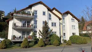 ein großes weißes Haus mit Büschen davor in der Unterkunft Exklusive Ferienwohnungen und Business Apartments Marburg in Marburg an der Lahn
