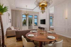 a living room with a wooden table and chairs at Plaza Apartments in Opatija