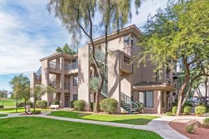 a large apartment building with a lawn and trees at Pure Suites Furnished 1, 2 and 3 Bed Apts Pool Gym Scottsdale Quarter in Scottsdale