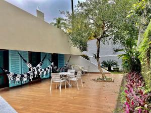 a patio with chairs and a hammock on a house at Vila linda com SPA e Piscina a 50 metros da Praia in Guarujá