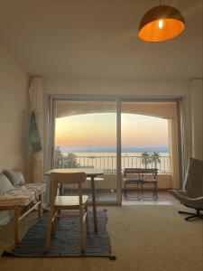 a living room with a table and a view of the ocean at Studio Le Brusc in Six-Fours-les-Plages