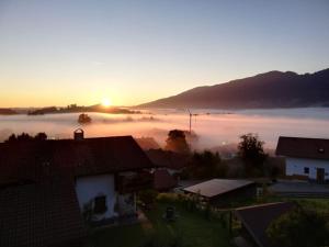 une vue sur une ville brumeuse avec le soleil en arrière-plan dans l'établissement Opas Bergchalet, à Halblech