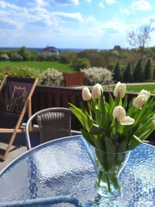 een vaas met witte bloemen op een tafel bij Staromiejska Apartamenty in Sandomierz