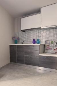 a kitchen with wooden cabinets and a sink at Summer Time Villa in Fira