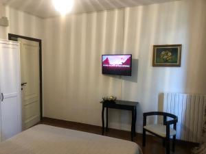 a bedroom with a bed and a tv on the wall at MA.DI BB in Rocca San Giovanni