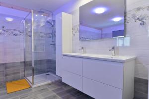 a white bathroom with a sink and a shower at Pension Na Vyhlídce in Janov nad Nisou