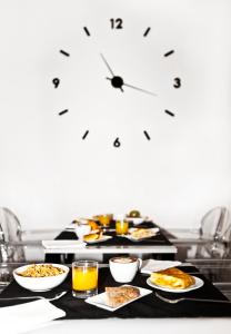 une table recouverte de assiettes de nourriture et de jus d'orange dans l'établissement Hotel Lux Santiago, à Saint-Jacques-de-Compostelle