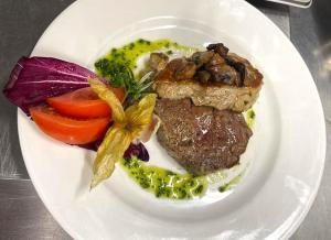 um prato de alimentos com carne e legumes sobre uma mesa em Hotel und Restaurant Nehrener Hof em Nehren
