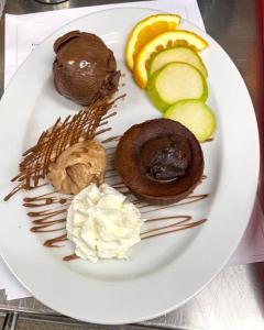 Hotel und Restaurant Nehrener Hof في Nehren: طبق من الطعام مع الكعك والتفاح والكريمة المخفوقة