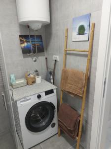 a laundry room with a washing machine and a shelf at # Espresso 2 Apartman sa garazom in Sremska Mitrovica