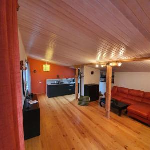 salon z czerwoną kanapą i drewnianą podłogą w obiekcie Studio apartment and FREE airport transfer w Rydze