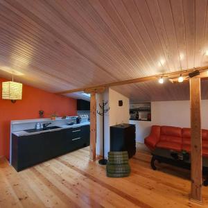 a living room with a red couch and a kitchen at Studio apartment and FREE airport transfer in Riga