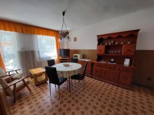 um quarto com uma mesa e cadeiras e uma cozinha em Petra Vendégház em Bük