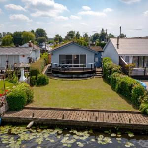 a backyard with a wooden walkway and a house at River View - Norfolk Broads in Brundall