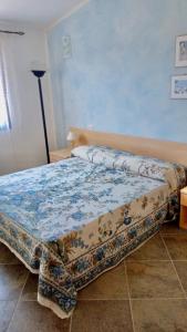 ein Schlafzimmer mit einem Bett mit einer Bettdecke darauf in der Unterkunft Condominio Ulivo in Valledoria