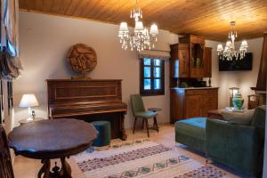 Una sala de estar con un piano y un sofá. en Dandy Villas Tsagkarada-Green Apple-Jacuzzi-Sea View, en Tsagkarada