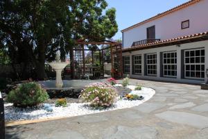 un patio con una fuente y flores frente a un edificio en VILLA LA CAPIROTA, en Lodero