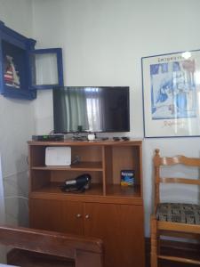 einen TV auf einem Holzständer mit einem Stuhl in der Unterkunft Aegean blue in Kallirákhi