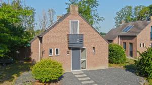 una casa in mattoni con una scala sul lato di Recreatiewoning Maas en Waal 191 a Ewijk