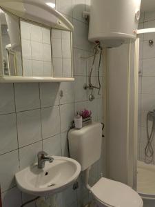 a white bathroom with a toilet and a sink at Apartment Mirror in Visoko