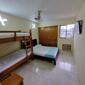 a bedroom with two bunk beds and a tv at Apartamento en Santa Marta- Rodadero Laureles 6 by reservastodo in Santa Marta