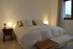 sypialnia z dużym łóżkiem z białą pościelą i oknem w obiekcie CasaSana Wellness w mieście Charbonier