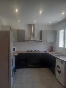 a kitchen with a stove top oven next to a sink at Villa san salvador Torreilles plage in Torreilles