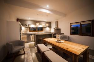 a large kitchen with a wooden table and chairs at CasaSana Wellness in Charbonier