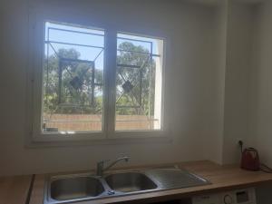 un comptoir de cuisine avec un évier et une fenêtre dans l'établissement Villa san salvador Torreilles plage, à Torreilles