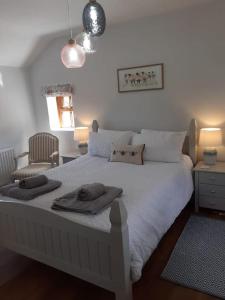 a bedroom with a white bed with two towels on it at Meadowsweet @ Laneside in Whitby