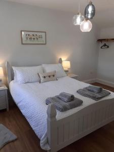 1 dormitorio con 1 cama con 2 toallas en Meadowsweet @ Laneside en Whitby