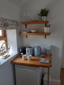 uma cozinha com um balcão de madeira com copos em Meadowsweet @ Laneside em Whitby