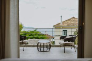 Habitación con vistas a un balcón con sillas y mesa. en Paleros Bay Villas en Paleros