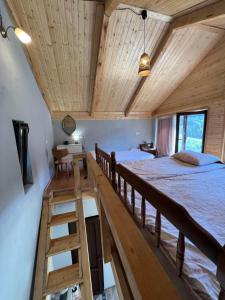 a bedroom with a bed and a ladder in a room at Mitarbi Silence - cozy holiday cottages in mountains in Borjomi