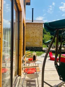 a patio with a table and chairs on a porch at Mitarbi Silence - cozy holiday cottages in mountains in Borjomi