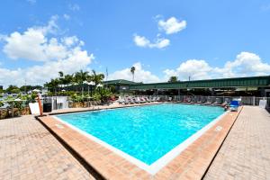 a large swimming pool with chairs and a building at Sarasota Cay Club #612 - Heated Pool, Bunk Beds, Huge TV, Tiki Bar, More! in Sarasota