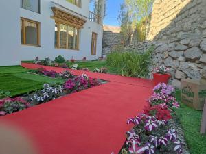 un tappeto rosso che conduce a una casa con fiori di Glacier View Guest House a Leh