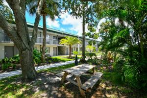 a wooden bench sitting in front of a building at Sarasota Cay Club #612 - Heated Pool, Bunk Beds, Huge TV, Tiki Bar, More! in Sarasota