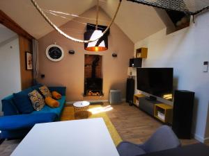 sala de estar con sofá azul y TV en Apartment Keleia, en Celje