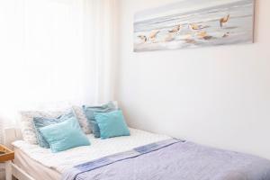 - une chambre avec un lit et des oreillers bleus dans l'établissement Pod Aniołem, à Mielno