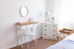 a bedroom with a white dressing table and a mirror at Pod Aniołem in Mielno