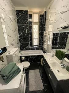 y baño en blanco y negro con bañera y lavamanos. en Luxury Riverside Panorama Apartment, en Budapest