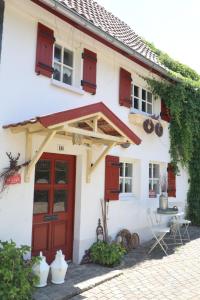 a white house with red doors and windows at Linne-Cottage in Willingen