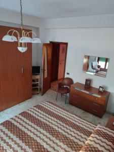 - une chambre avec un lit, une commode et un miroir dans l'établissement Appartamento Elisa, à Melito di Porto Salvo